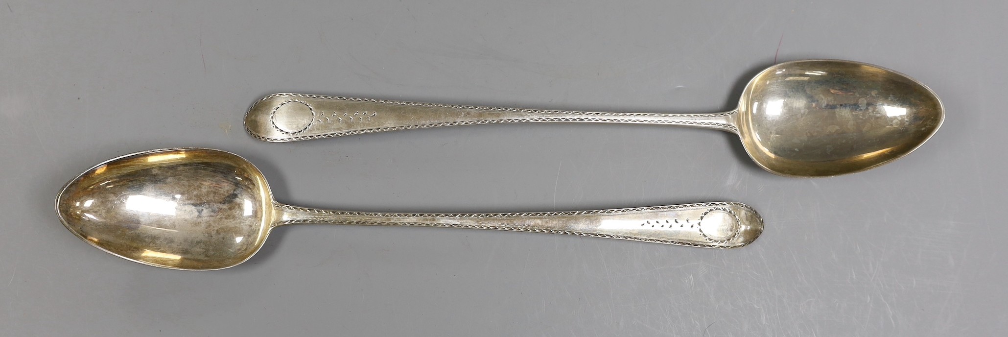 A pair of George II Irish silver bright cut engraved basting spoons, Michael Smith, Dublin, 1754 & 1757, 31.8cm, 6.3oz.